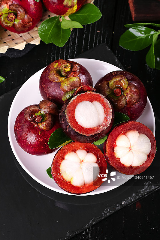 黑石板上放着一盘泰国新鲜山竹图片素材