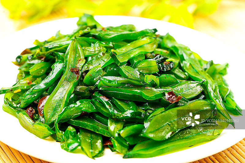 木底上放着一盘香辣海白菜图片素材