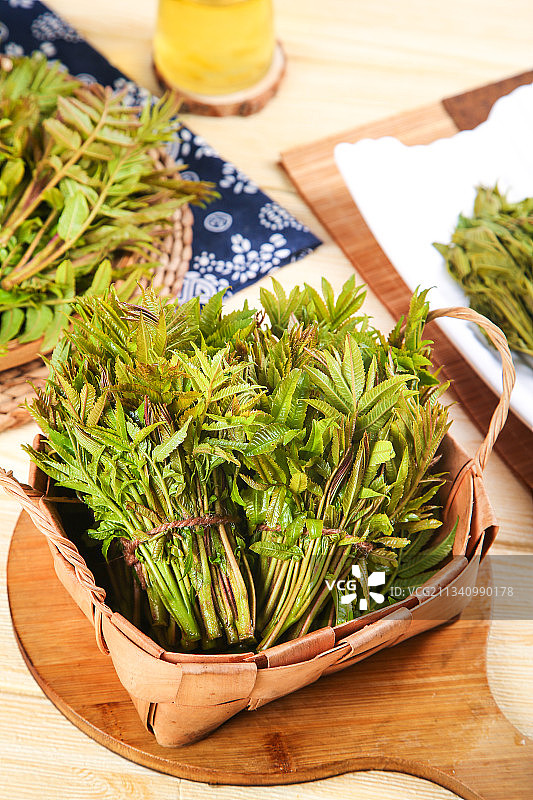 一筐香椿芽放在木底上图片素材