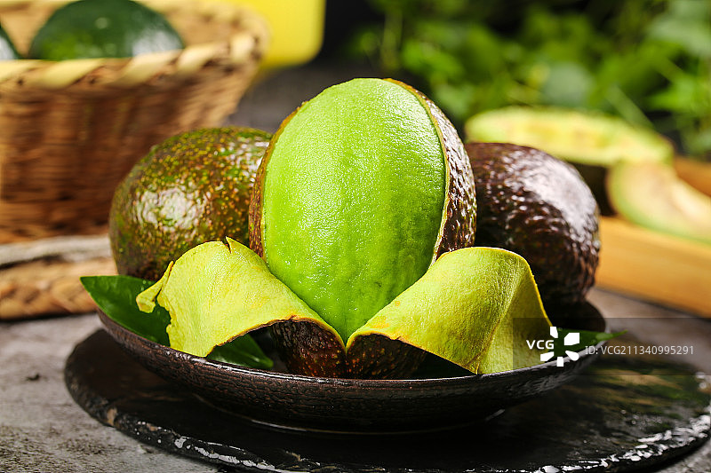 黑石板上放着削皮的墨西哥牛油果图片素材