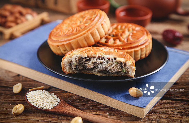 一盘五仁月饼放在木底上图片素材