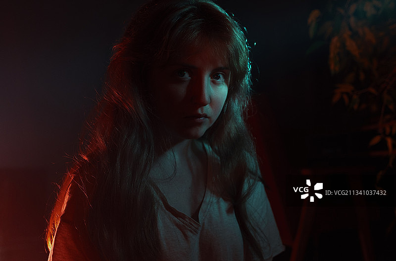 在暗房中若有所思地望向远方的年轻女子特写，波兰图片素材