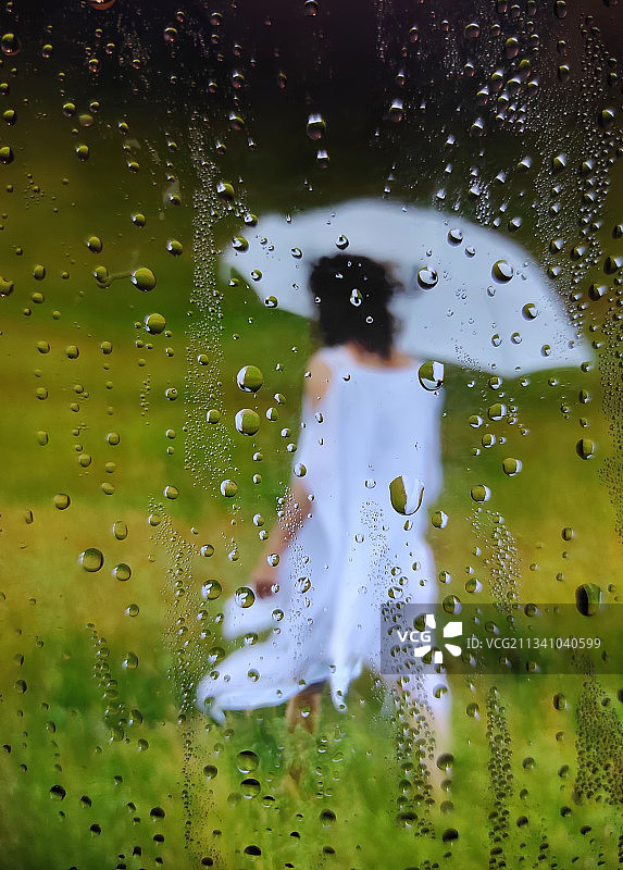 雨季透过潮湿窗户看到的女人，匈牙利图片素材