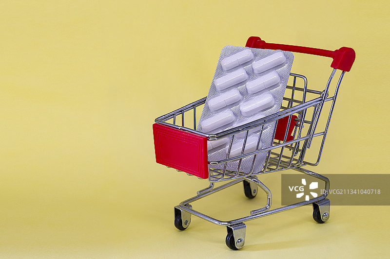 黄色背景上的购物车特写，马德里，西班牙图片素材