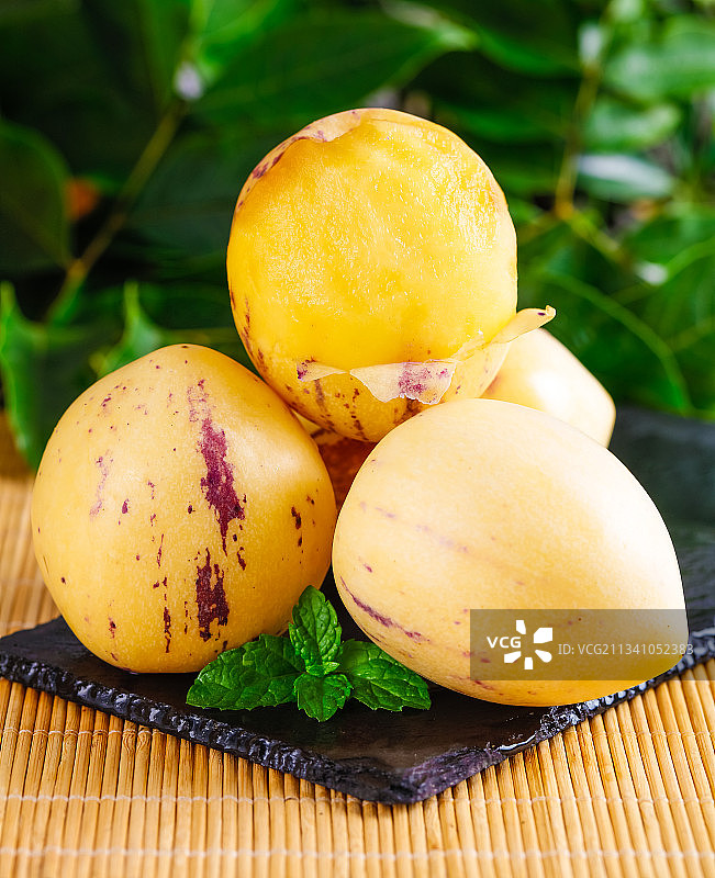 黑石板上放着黄肉人参果图片素材