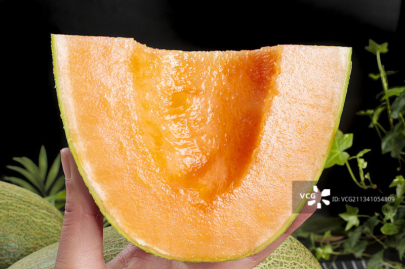 手拿切开的哈密瓜图片素材