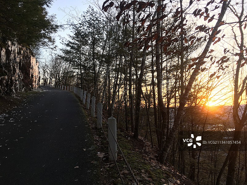 美国马萨诸塞州日落时分树林间的空旷道路图片素材