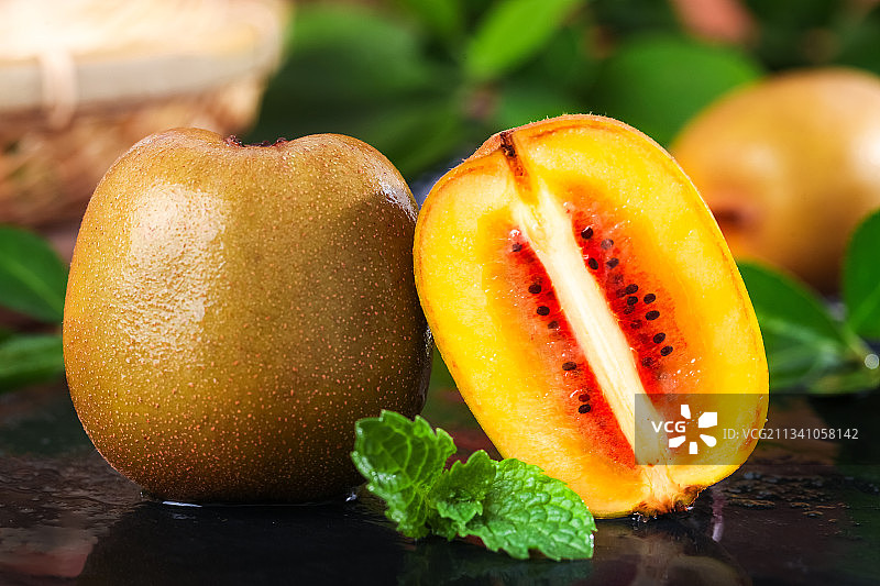 黑石板上放着切开的红心猕猴桃图片素材