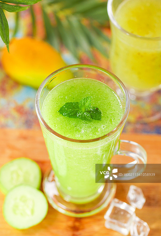 木底上放着一杯黄瓜果汁图片素材