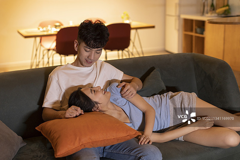 快乐的年轻夫妇在家看电视图片素材