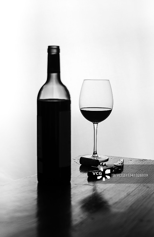 白色背景下桌上的葡萄酒瓶特写图片素材