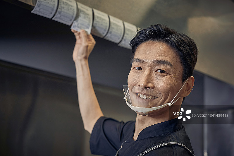 餐厅厨房、厨师、烹饪、准备、男性、订单、微笑、快乐、满意图片素材