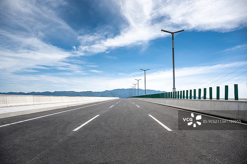 夏日蓝天白云下空旷的柏油马路图片素材