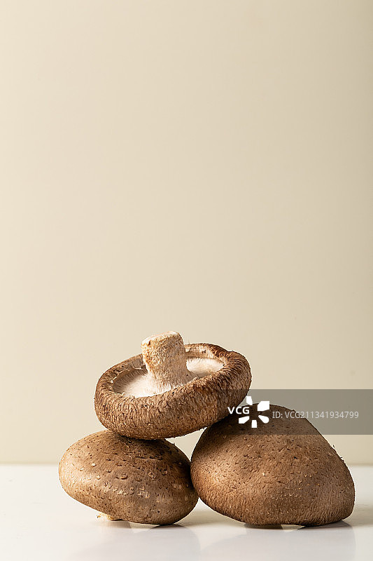 米色背景三朵香菇重叠图片素材