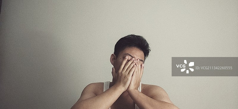 灰色背景下掩面的男人图片素材