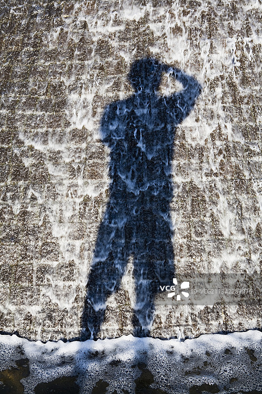 成人投射在斑驳混凝土表面的影子图片素材