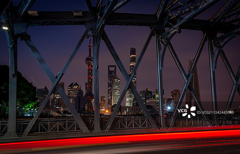 日出前的外白渡桥钢结构和浦东陆家嘴天际线，车流拉出红白色轨迹图片素材