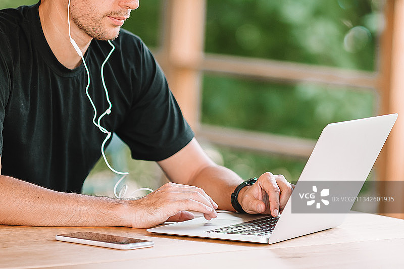 在桌旁使用笔记本电脑的男人图片素材