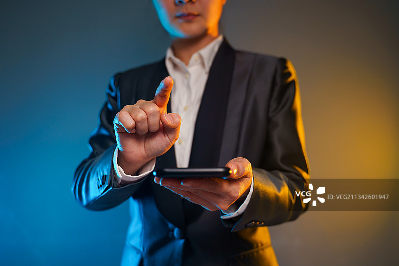 商人对着灰色背景使用平板电脑图片素材