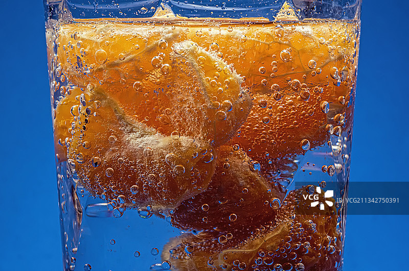 蓝色背景下的玻璃杯饮品特写图片素材