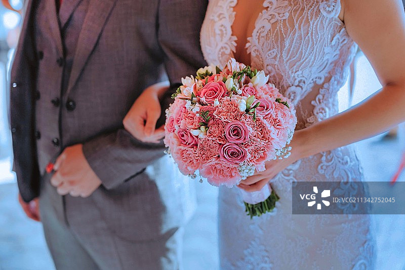 新娘和新郎手捧花束的腰部特写图片素材