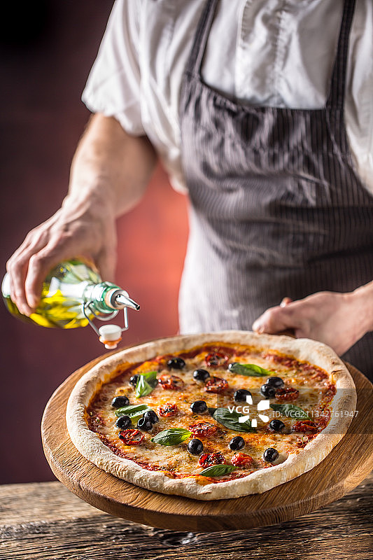 男子在桌子上准备披萨的腰部特写图片素材
