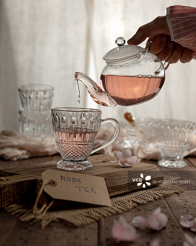 在桌子上将茶倒入杯中图片素材