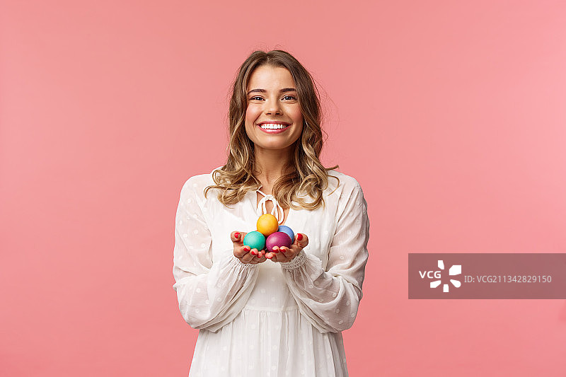 对着粉色背景拿着碗里水果的微笑女人肖像图片素材