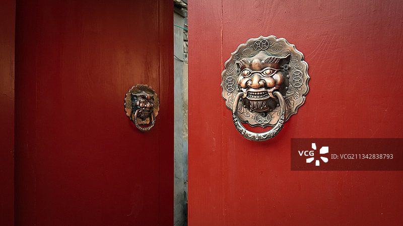 北京胡同街头，四合院的大红门和红铜兽首门环。图片素材