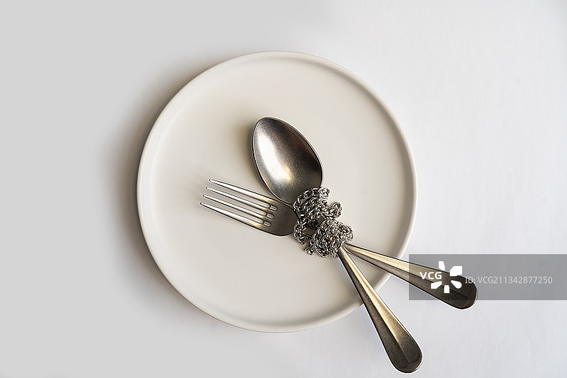 空盘子中被链条捆绑的餐具图片素材