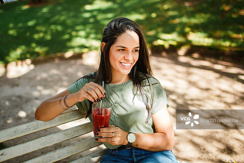 在巴西米纳斯吉拉斯州贝洛奥里藏特用金属吸管喝果汁的女人图片素材