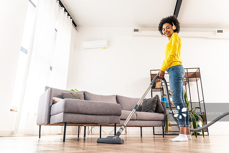 快乐的非洲裔妇女打扫家图片素材