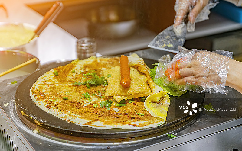 室内商场里一个人正在烹饪制作煎饼果子图片素材
