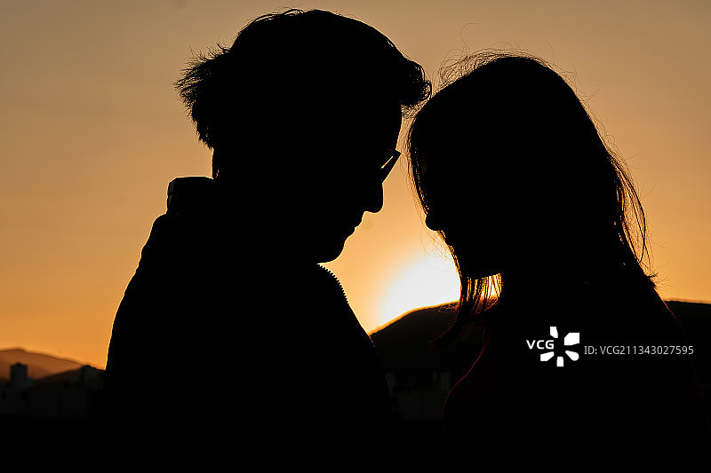 日落时分，情侣在天空下的轮廓图片素材