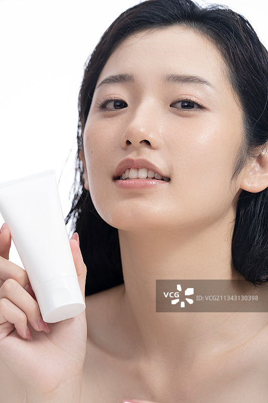 精致的东方女人拿着护肤品图片素材