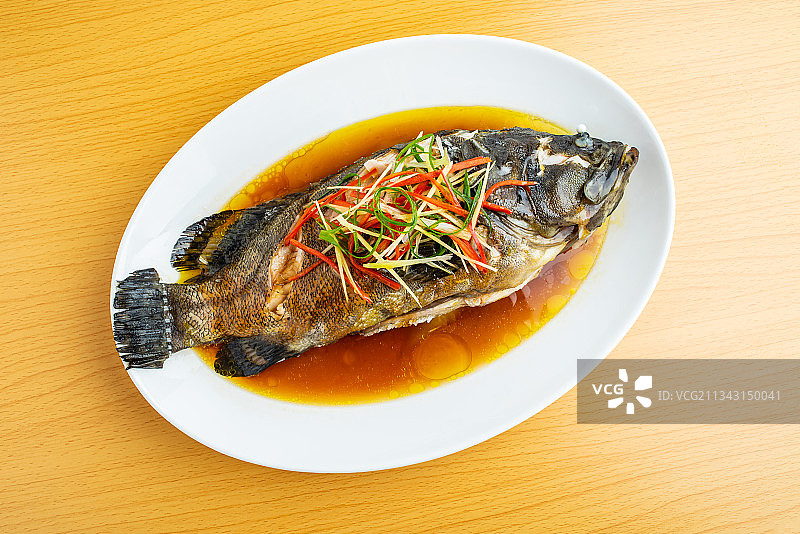 木桌上一碟粤菜清蒸石斑鱼图片素材