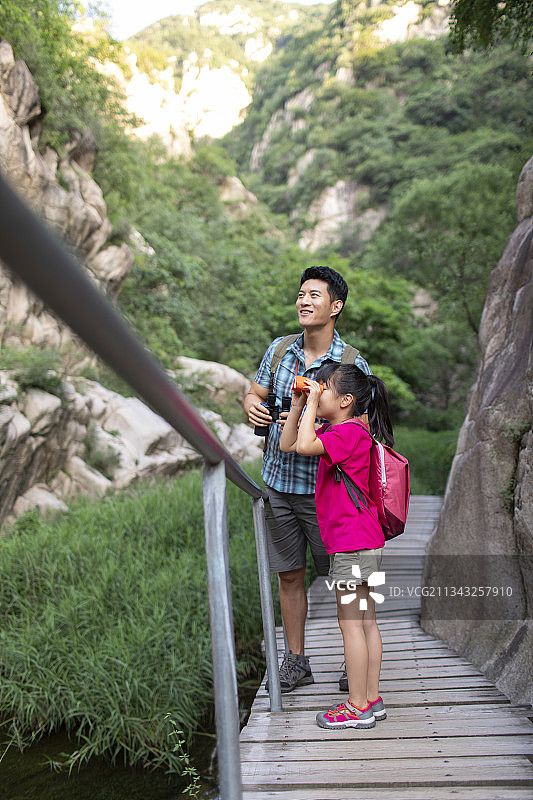 快乐的小女孩和爸爸使用望远镜图片素材