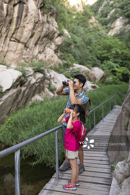 快乐的小女孩和爸爸使用望远镜图片素材