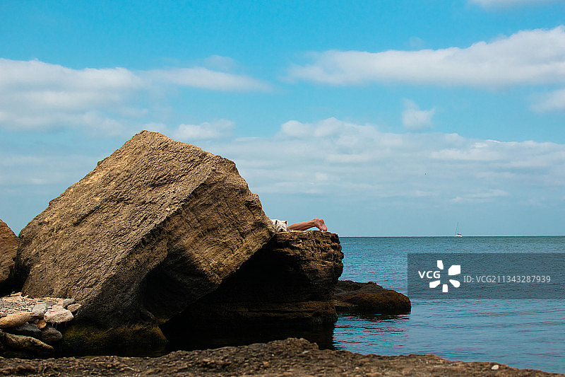 海滩上岩石对着天空的风景图片素材