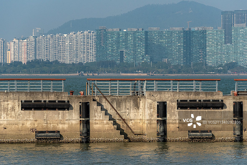 深圳湾公园的码头和远处香港元朗区的楼群图片素材