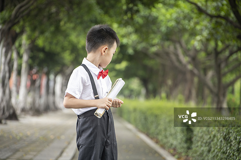 手里拿着书回头看路的小学生图片素材