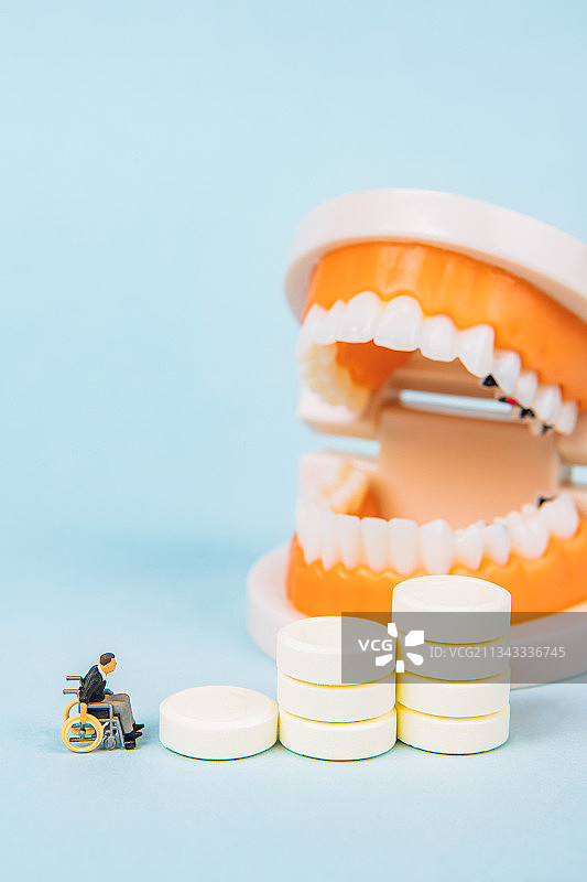坐轮椅的老人面对钙片和牙齿需要补钙图片素材