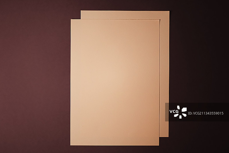 深色背景上的米色空白A4纸，作为办公文具平面图图片素材