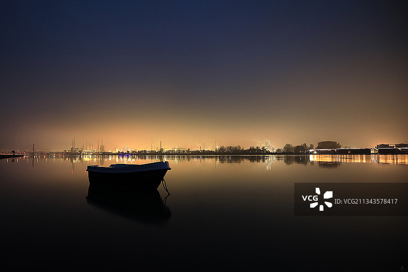 奥地利林茨，日落时分晴朗天空下湖中的船只剪影图片素材