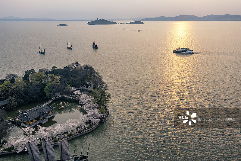 黄昏时晚霞中的无锡鼋头渚樱花和太湖的游船图片素材