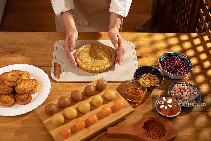 圆形,巨大的月饼,人的手,制作图片素材