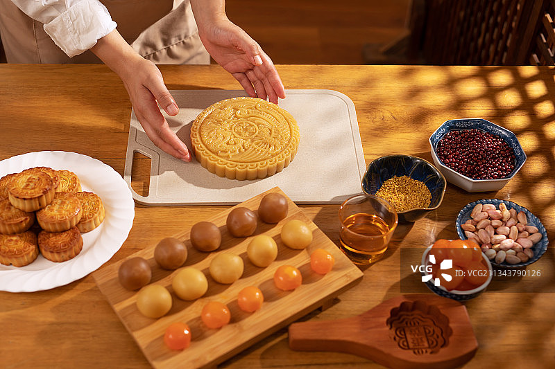 圆形,巨大的月饼,人的手,制作图片素材