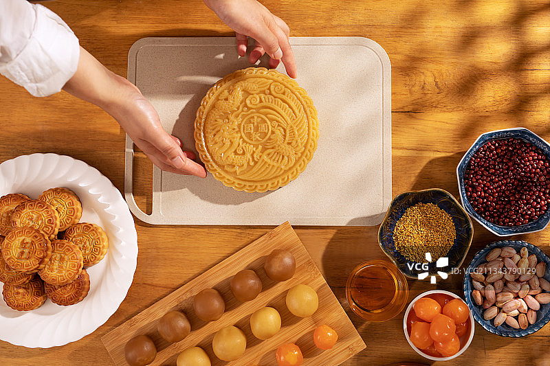 圆形,巨大的月饼,人的手,制作图片素材