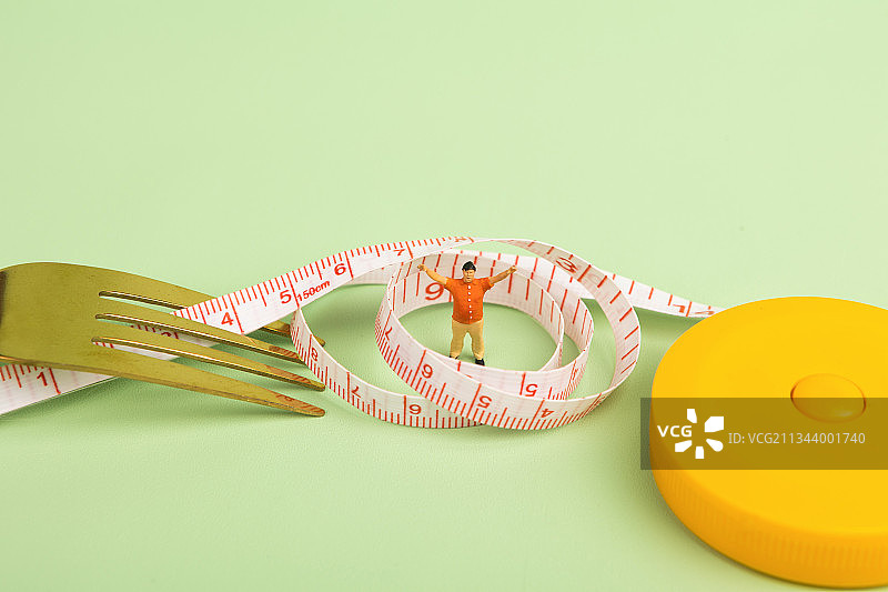 微缩景观刀叉和胖子被卷尺困住健身减肥图片素材