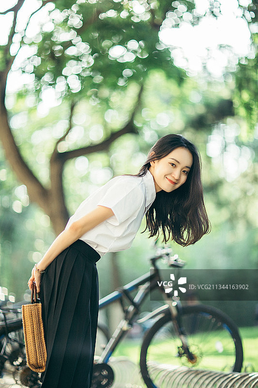 东方美女大学生在校园里注视镜头微笑图片素材